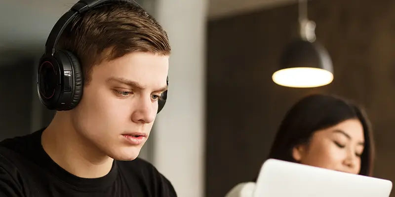Junger Erwachsener arbeitet konzentriert am Computer