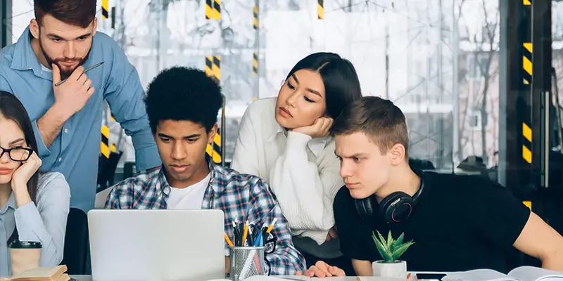 Junge Erwachsene arbeiten im Rahmen der Ausbildung Informatiker/in EFZ Plattformentwicklung gemeinsam am Laptop